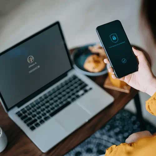 手持手机，屏幕上显示设备受保护的通知