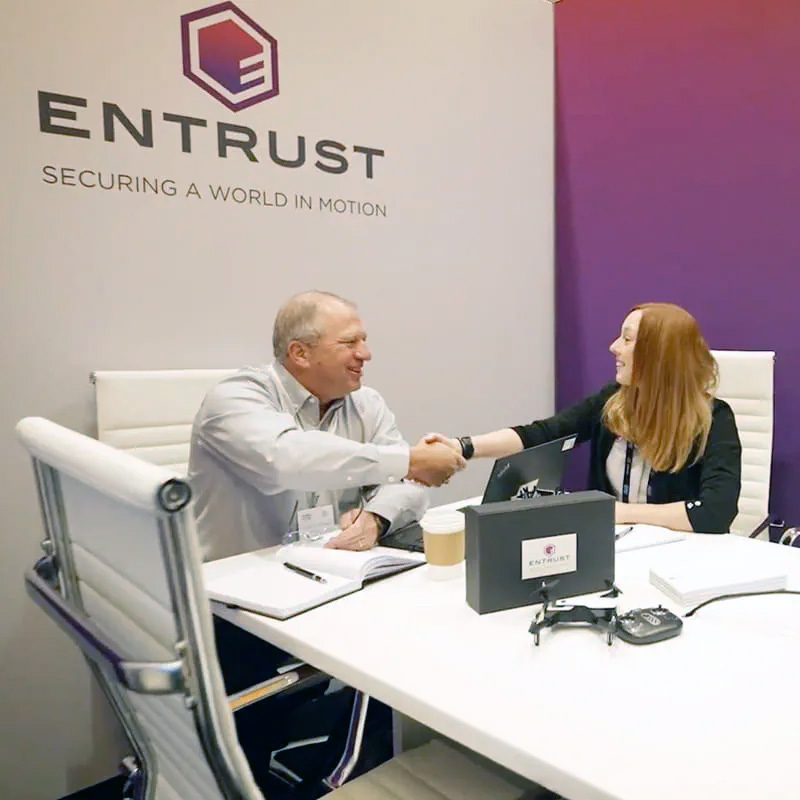 Two people sitting at a table and shaking hands