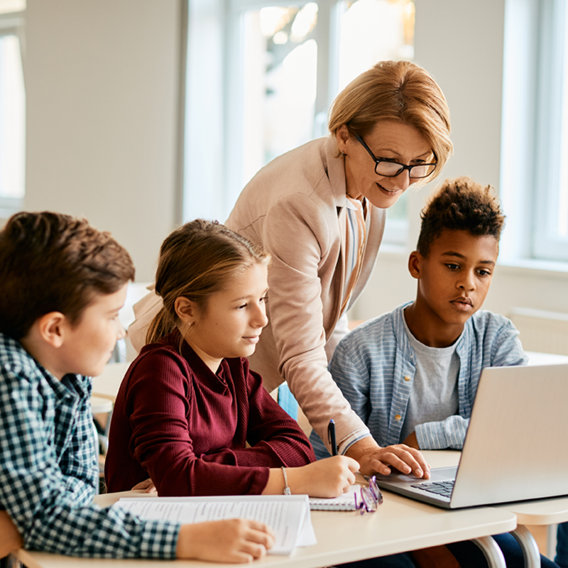 Woman helping kids with a laptop