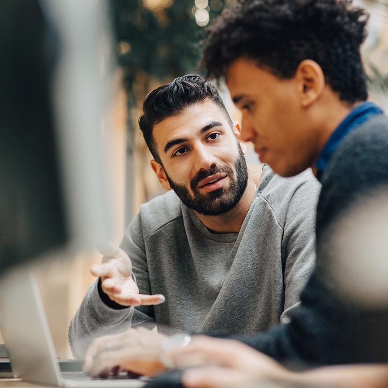 Two people discussing something in front of a computer