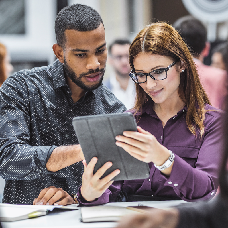 Two people looking at a tablet