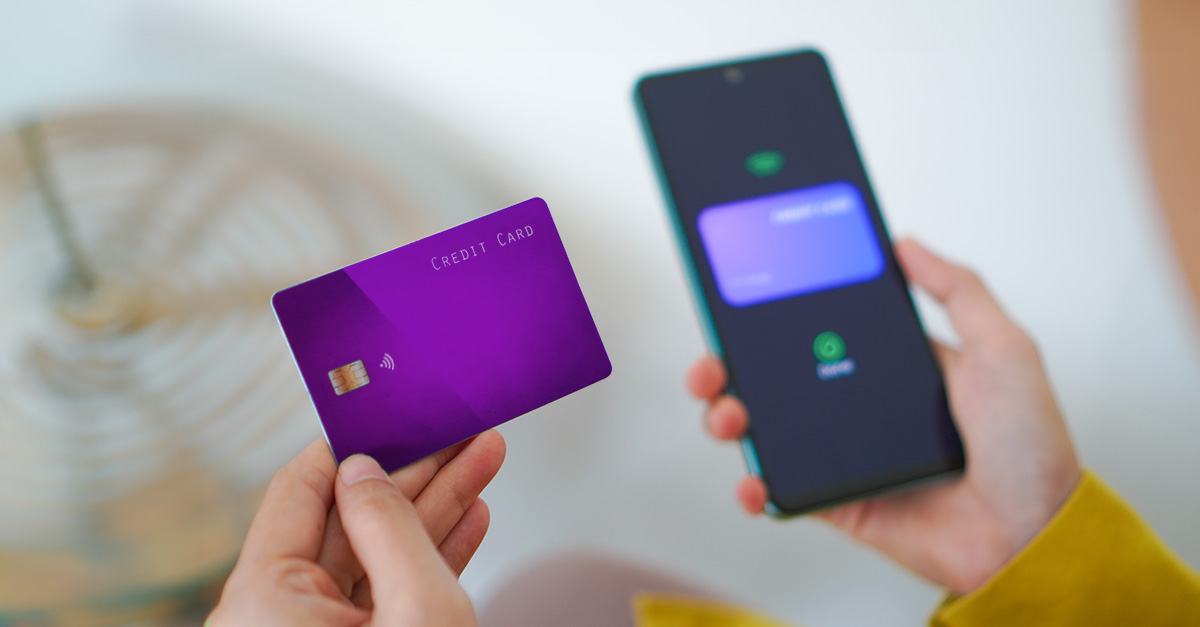 Person holding a financial card and phone