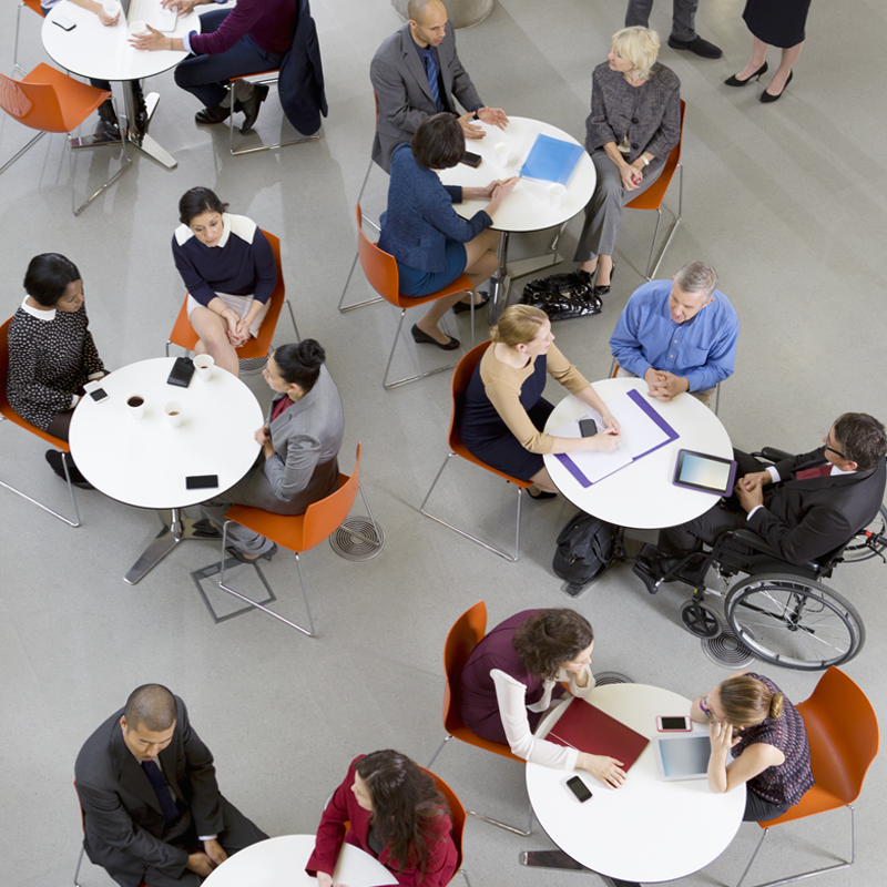 Many people sitting at small tables