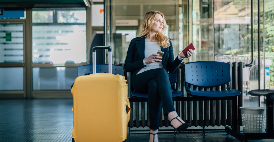 Woman sitting in a chair next to a suitcase