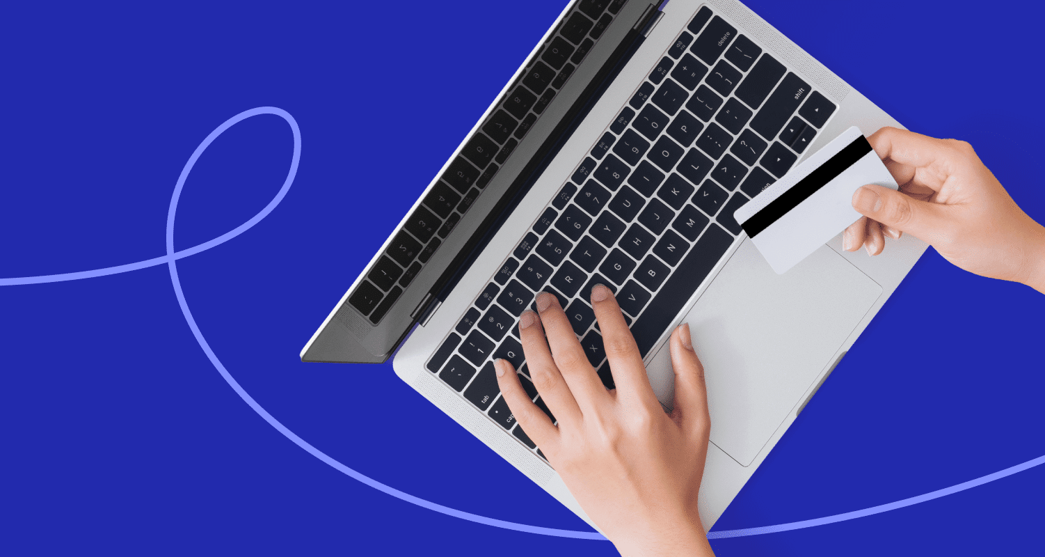 Person using a laptop and holding a card