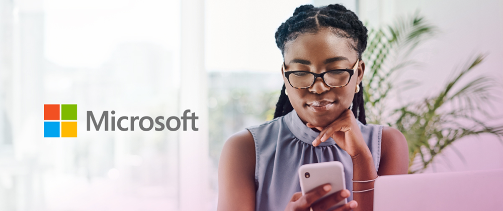 microsoft logo next to girl wearing glasses looking at mobile device