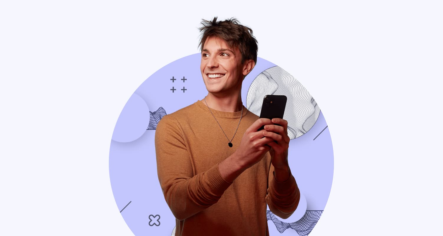 smiling man wearing brown sweater holding mobile phone