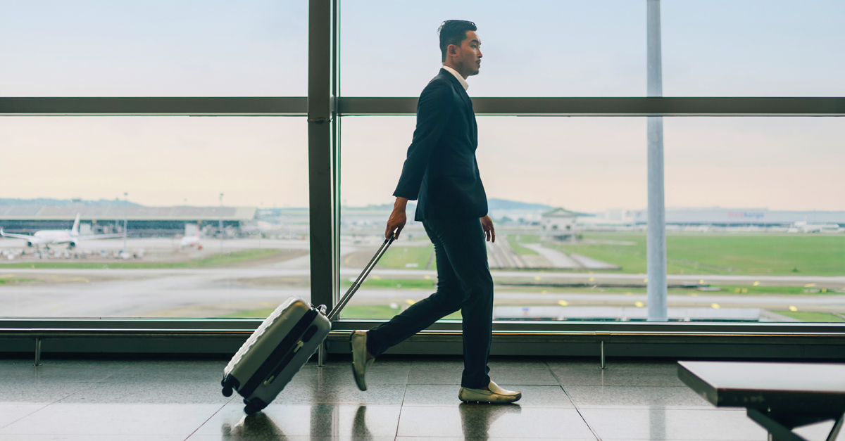 Man walking in an airport pulling baggage
