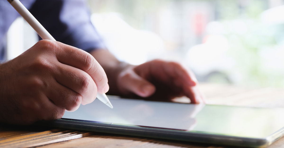 Person writing on a tablet