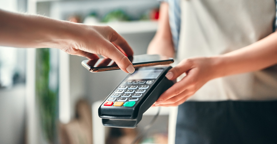 hand holding a phone over a credit card reader