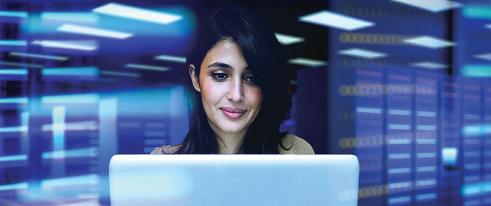 Woman on laptop in server room