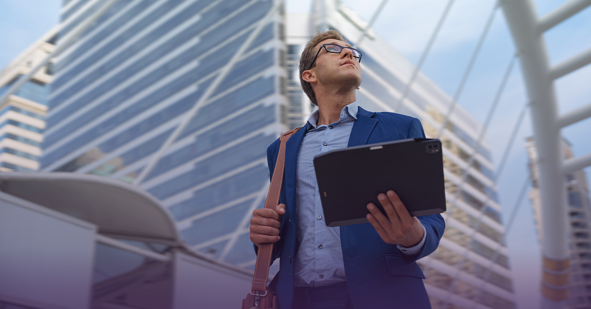 Man walking outside and holding a tablet