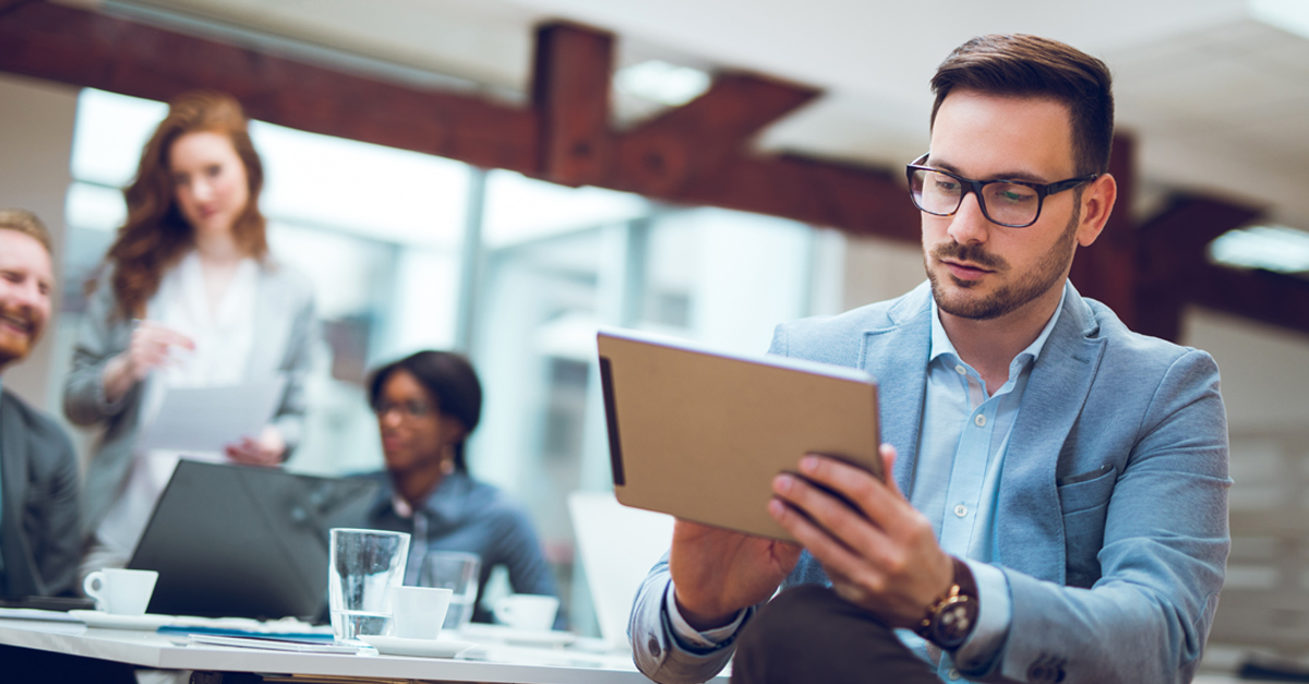 Man sitting down and using a tablet