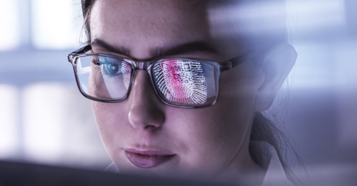 Close-up of a person wearing glasses, shown through a softly lit, reflective surface