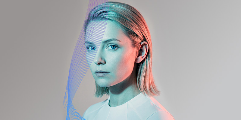 profile of woman with short blonde hair and tech wave background