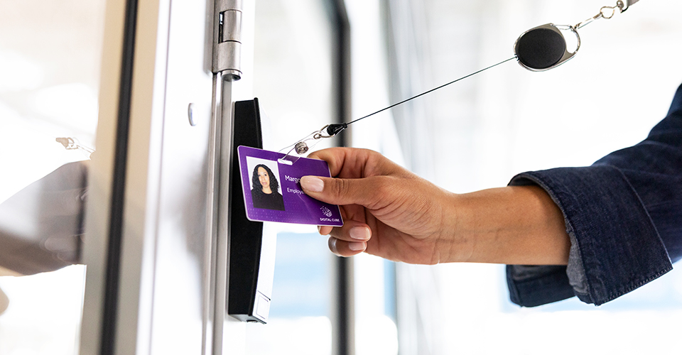 Employee badge being scanned at a door access reader