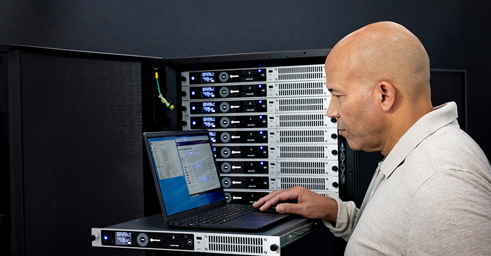 Person using a laptop in a server rack environment