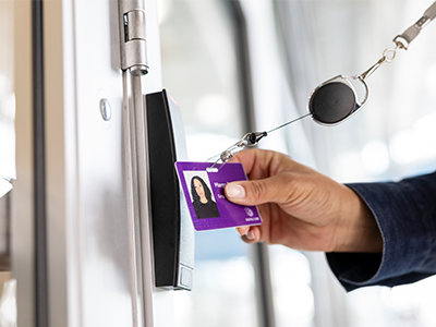 hand using ID card at door access