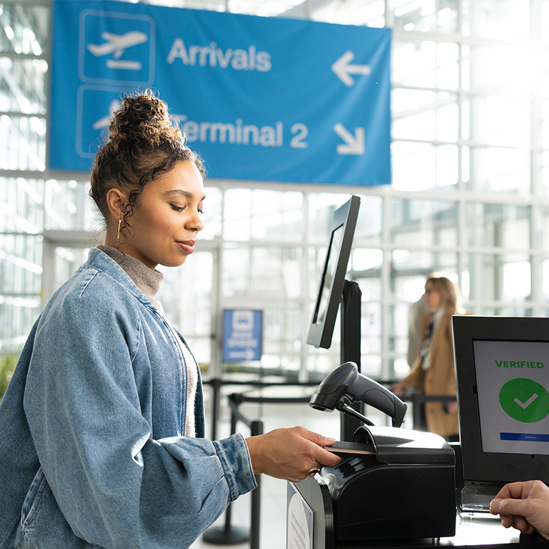 Traveler verifying identity at an airport kiosk with digital ID confirmation screen