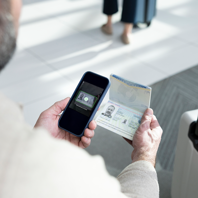 Person using a smartphone to scan and verify a passport for identity proofing