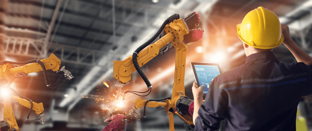 Worker holding a tablet operating machines.