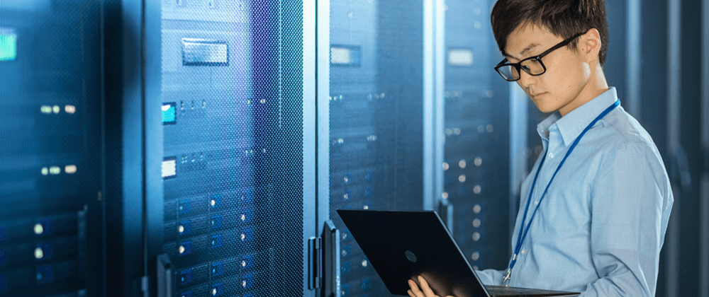 Man using a laptop in a server room