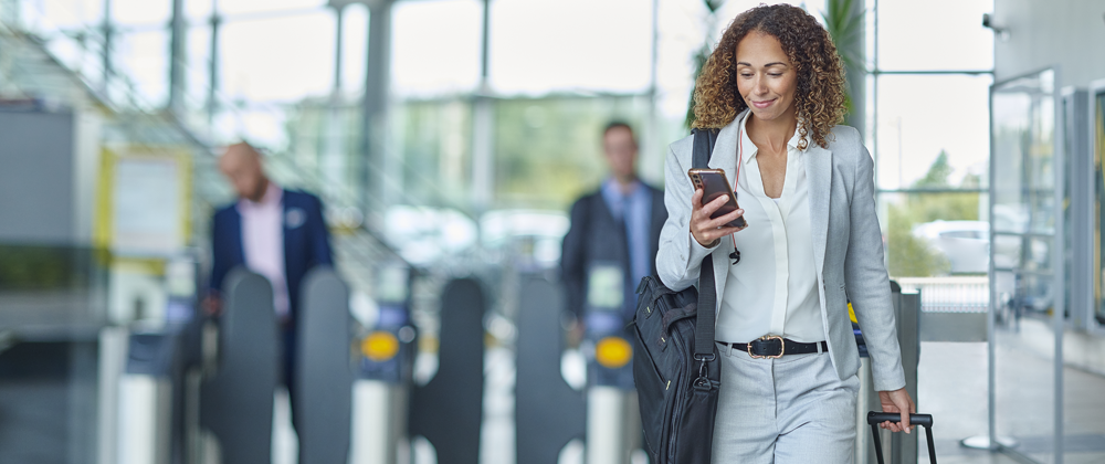 Woman using a phone and walking in an airport