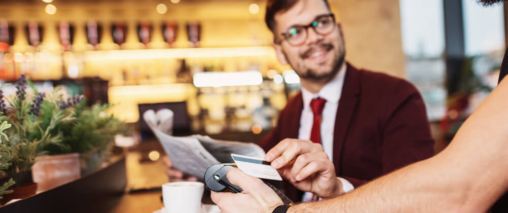 man using contactless payment with card at restaurant